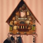 Timber decorative retro house with seashells and hanging keys on pink wall with stripes